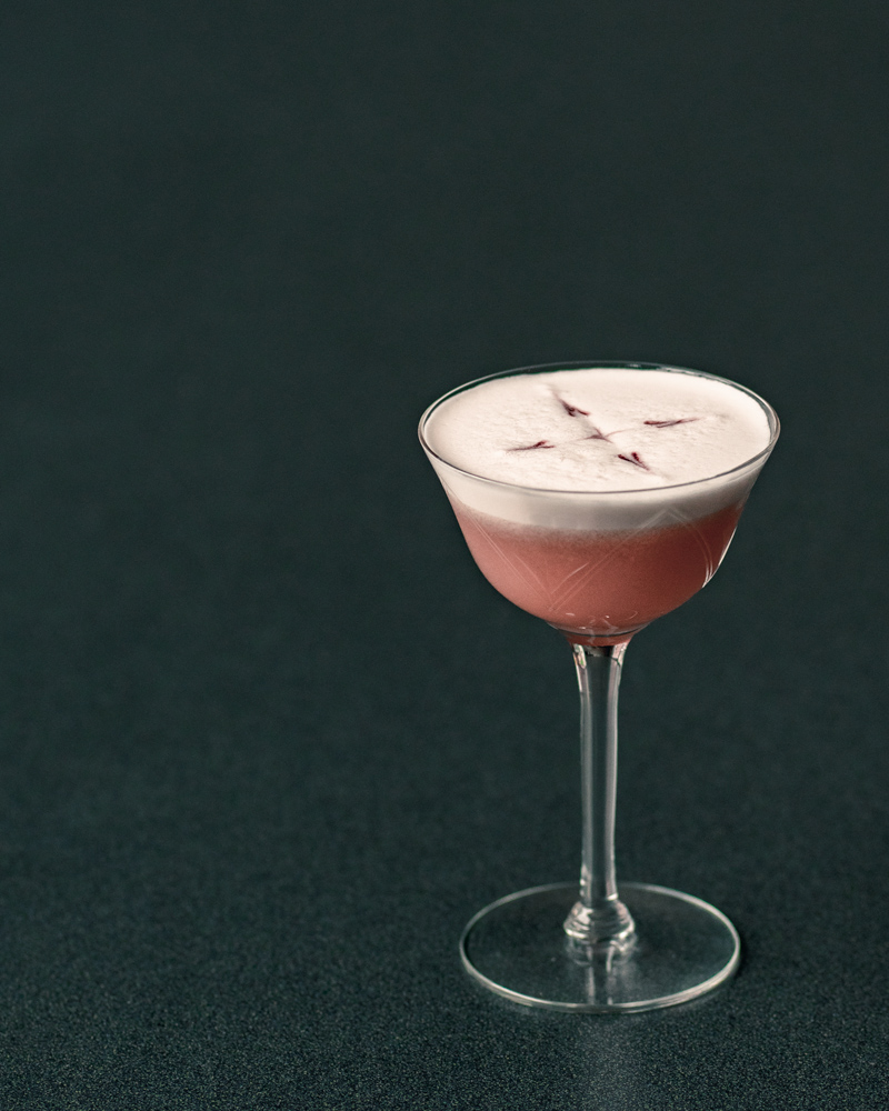 The Pink Lady cocktail with egg white foam and bitters on top