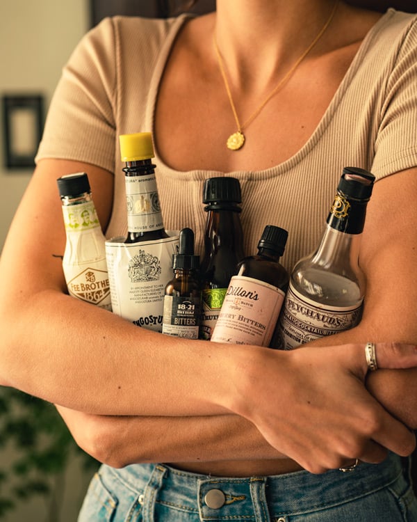 holding different bitters bottles